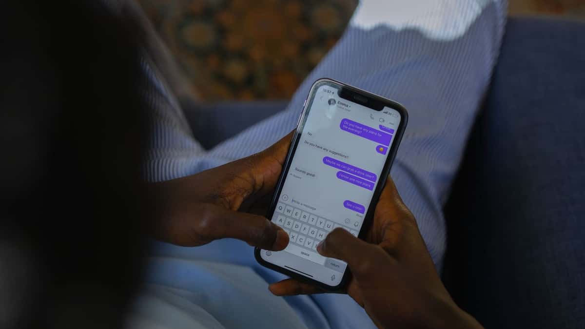 Manos escribiendo un mensaje en un teléfono móvil