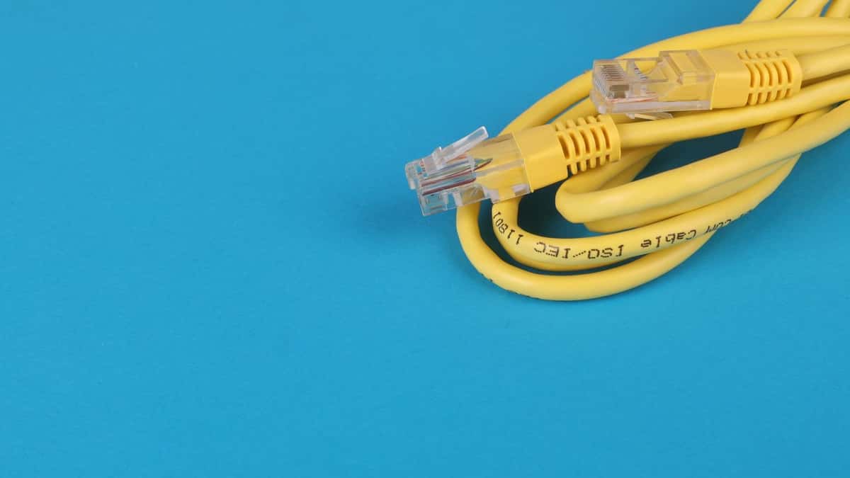 Cable de red amarillo enrollado sobre un fondo azul